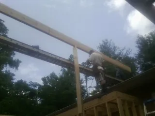 Carpenter setting a ridge beam over a new addition frame — Ice Dam Removal by Roofing Brothers in Mound