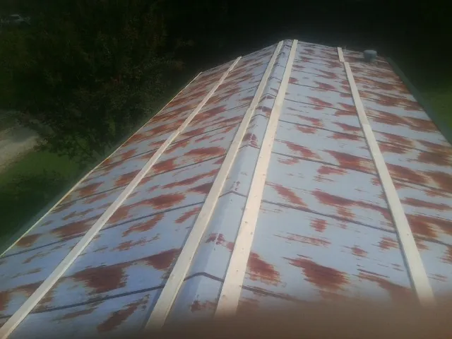 Rusted metal roof panels with new wood purlins before replacement — Storm Damage Roof Repair in Mound by Roofing Brothers