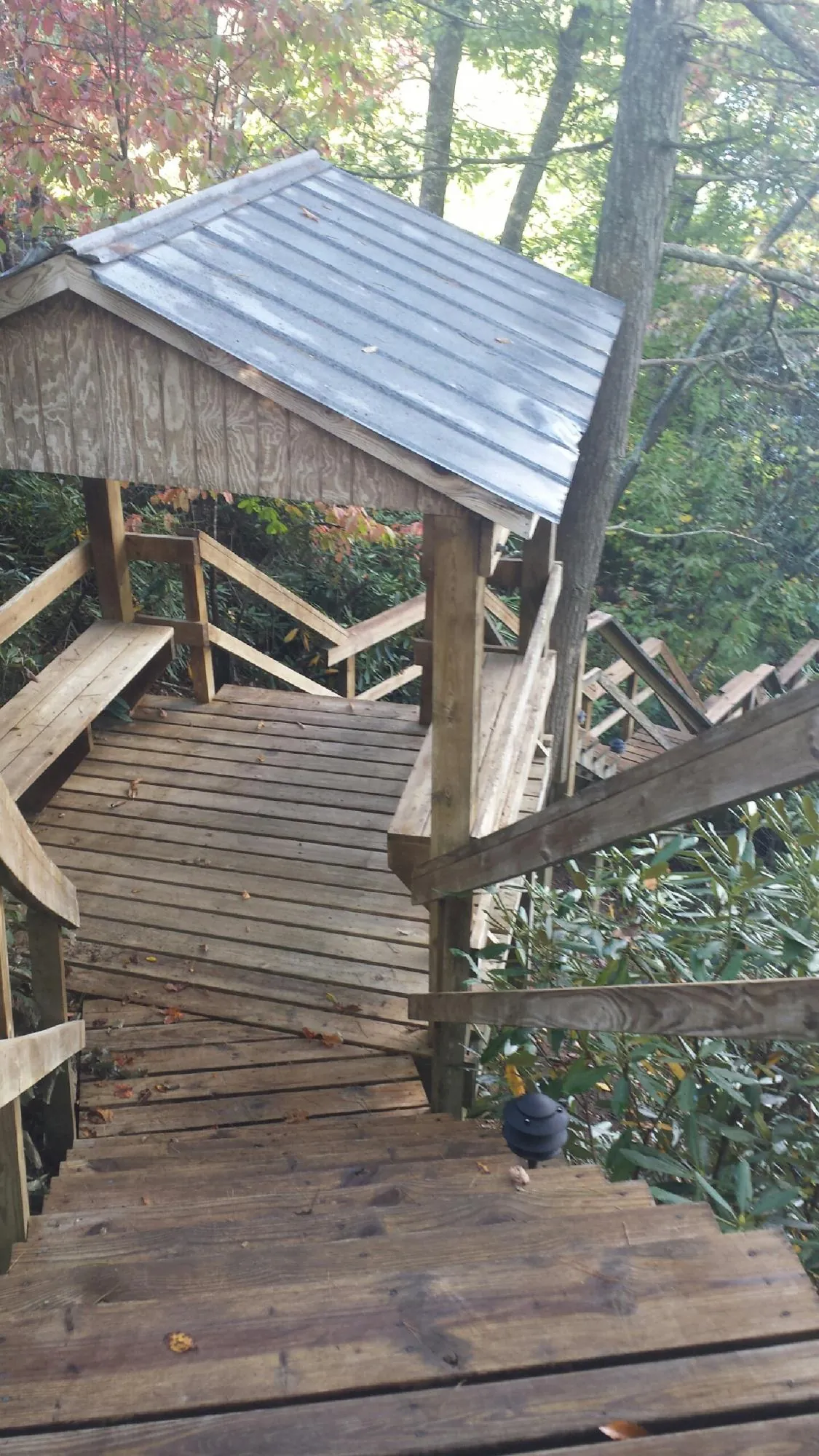 Metal roofed shelter over wooden steps on a wooded walkway — Skylight Repair & Installation work by our crew in Mound
