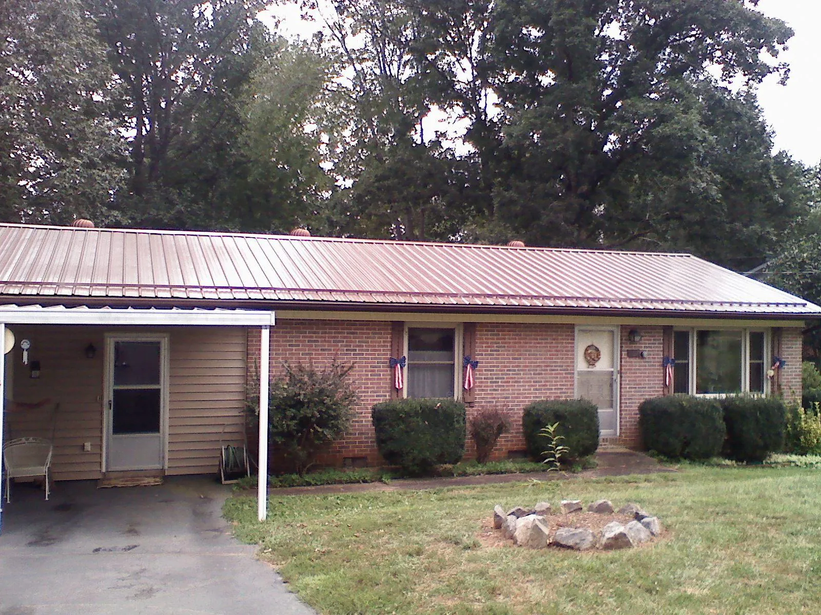 Bronze metal roof and carport on a brick ranch home — Roof Repair work by our crew in Mound